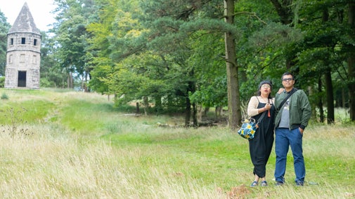 Visitors on the Lantern walk at Lyme Park, Cheshire with trees and a tower in the background